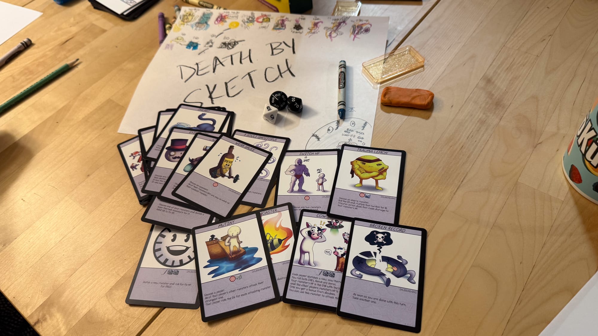 A photo of a table with cards for the game Death By Sketch