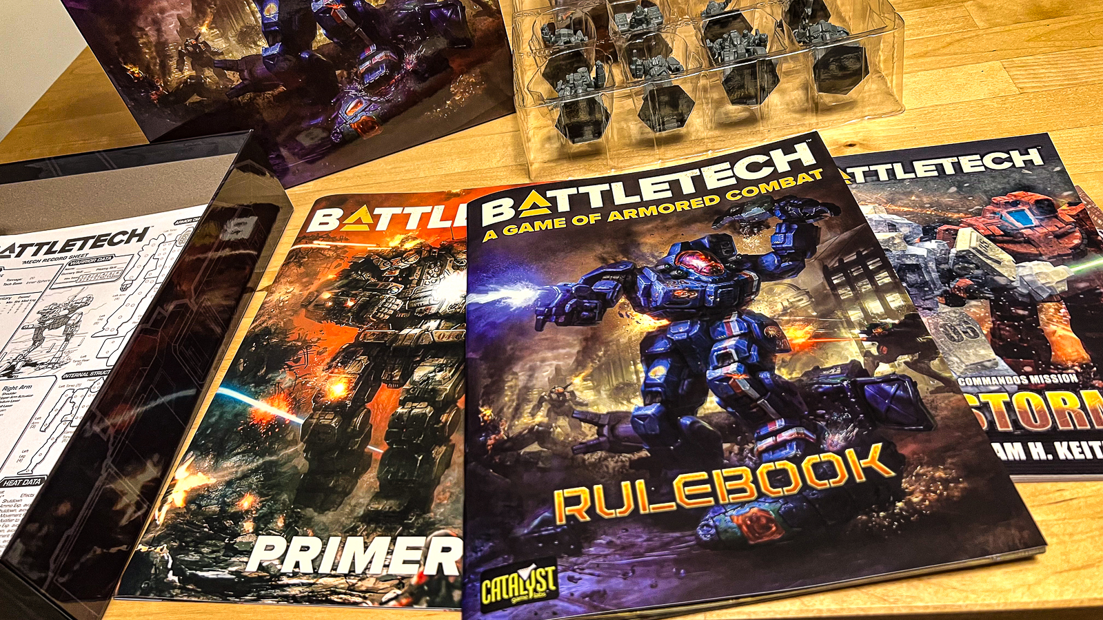 A photo of the contents of the Battletech box set, including rules, minis, and some additional materials.