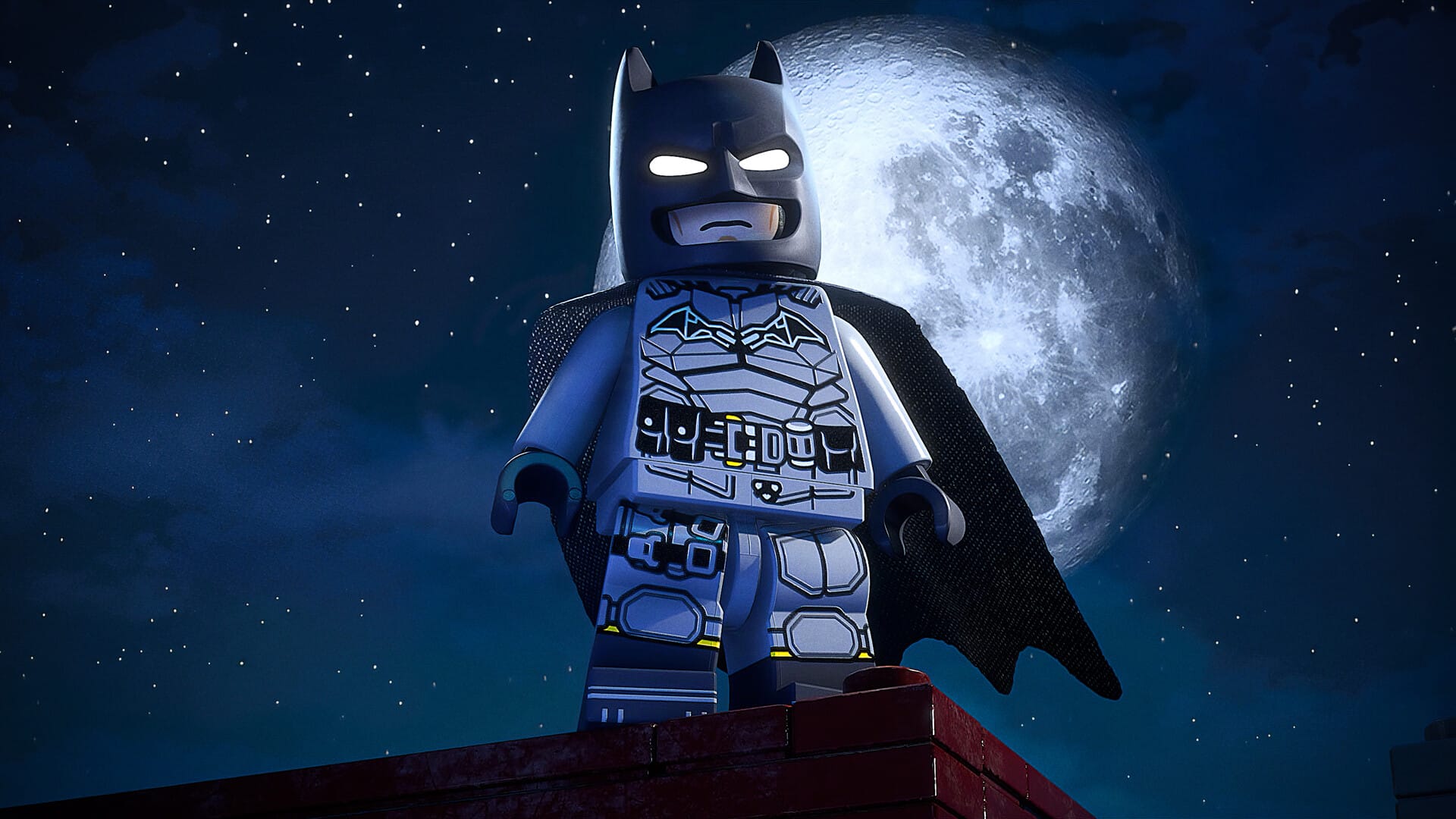 Batman posing in front of the moon on a rooftop.