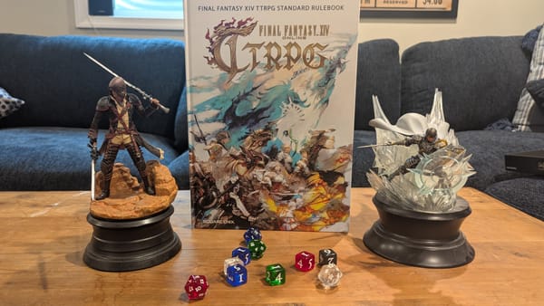 The hardcover FFXIV TTRPG book surrounded by dice from the starter set and two statues of the Warrior of Light