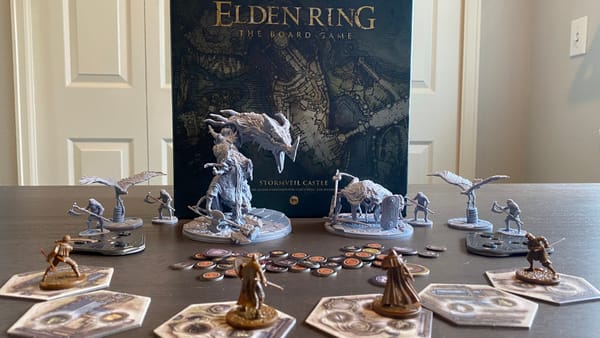 The Stormbeil Castle box cover is surrounded by the enemy miniatures from the game, while the player miniatures form a semicircle around them. Additional components are scattered throughout