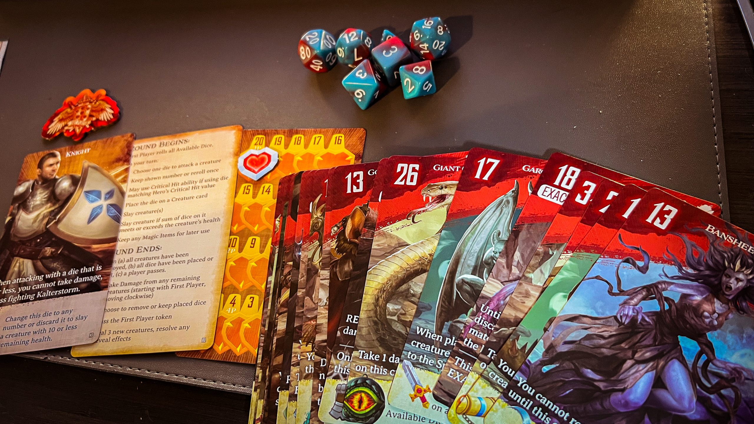 An image of the dice conquest game, showing creature cards, dice, instructions