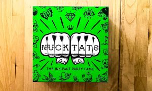 The box art of Nuck Tats, a card game. Shows two fists with the name Nuck Tats written on the fists