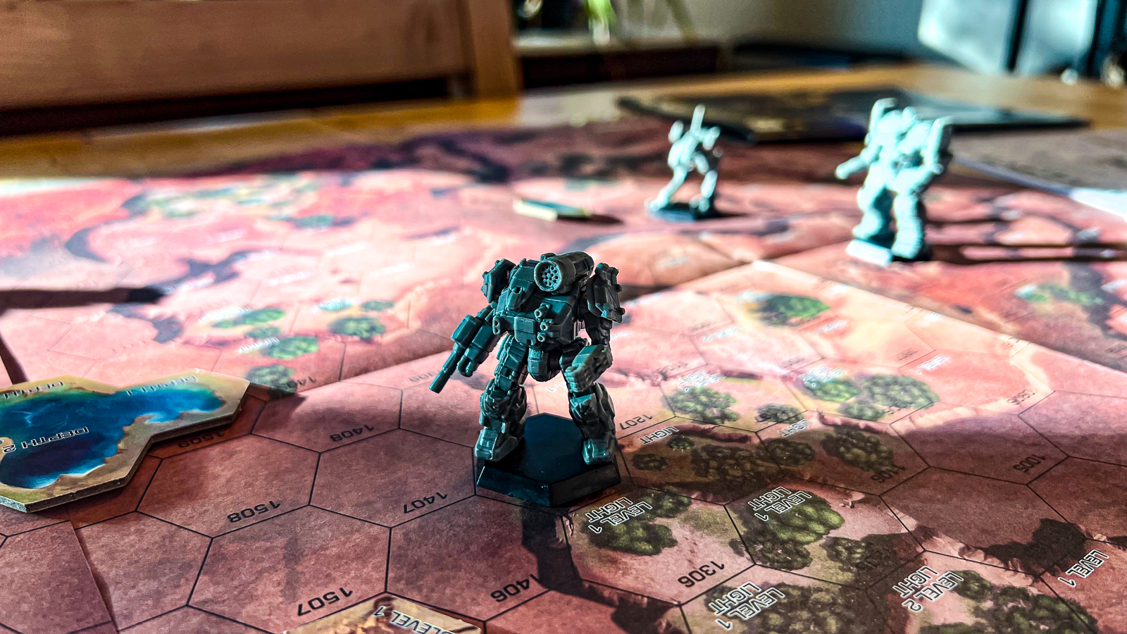 A photo featuring a battletech mini on a playmat